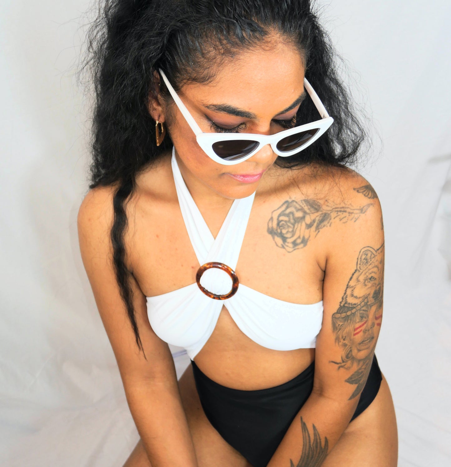 white and black bathing suit with adjustable brown ring for front cleavage.
