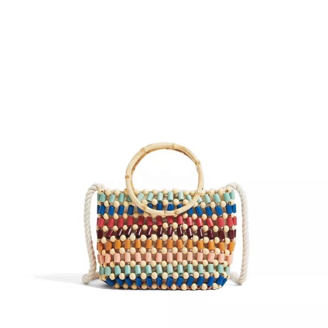 colorful beaded handbag with bamboo handles.